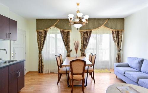 a kitchen and dining room with a table and a blue couch at Residence Romanza in Mariánské Lázně