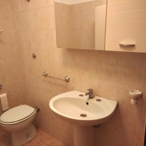 a bathroom with a white sink and a toilet at SENZATESTA 2 in Osimo