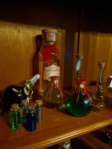 - une étagère avec deux bouteilles d'alcool dans l'établissement Le Gîte Ensorcelé, à Saint-Jean-Soleymieux
