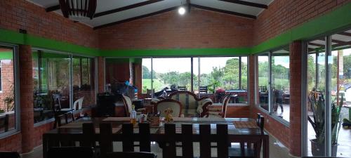 a dining room with a table and some windows at Finca Hotel el Vergel Filandia Quindio in Filandia