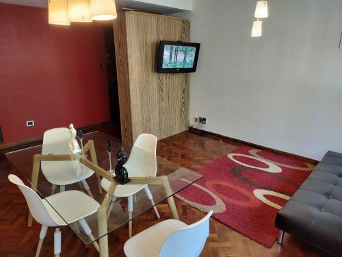 sala de estar con sillas, mesa y TV en Bombal 1 a pasitos de Arístides en Mendoza