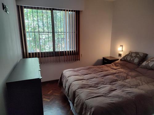 1 dormitorio con cama y ventana grande en Bombal 1 a pasitos de Arístides en Mendoza