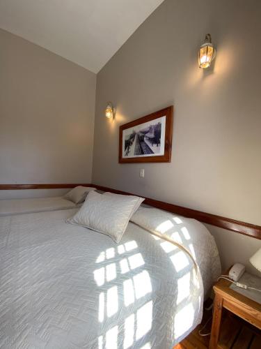 a bedroom with a bed and a picture on the wall at Hotel Vicente López in Vicente López