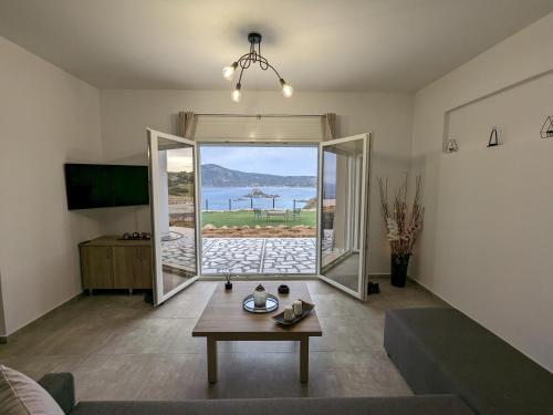 a living room with a table and a view of the ocean at Cute apartments in Kefalos