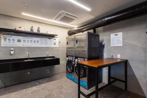 uma cozinha com máquina de lavar e secar roupa num quarto em Tabas - Pivô Match - Vila Nova Conceição em São Paulo