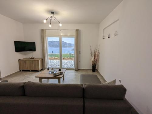 a living room with a couch and a tv at Cute apartments in Kefalos