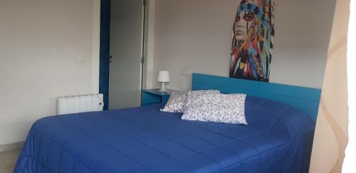 Cama azul con cabecero azul y almohada en Pension Doña Lubina, en Finisterre