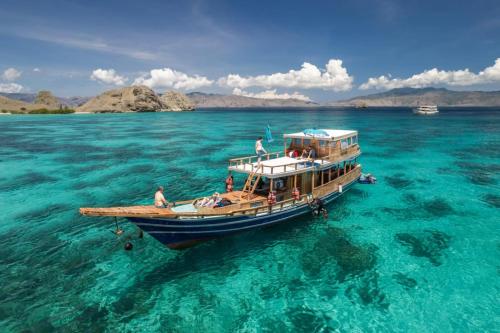 una barca galleggiante nell'acqua dell'oceano di Komodo Tour 1-6 Pax 2 Days 1Night a Labuan Bajo