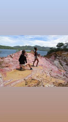 two children walking on the shore of a body of water at Komodo Tour 1-6 Pax 2 Days 1Night in Labuan Bajo