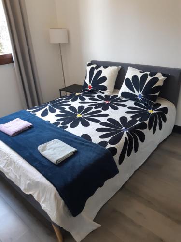 - un lit avec une couverture et des oreillers bleus et blancs dans l'établissement Appart bas Fabron, à Nice