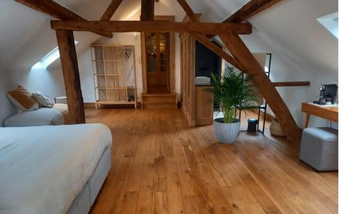 una camera con letto e pavimento in legno di Ca'Triz a Borgloon