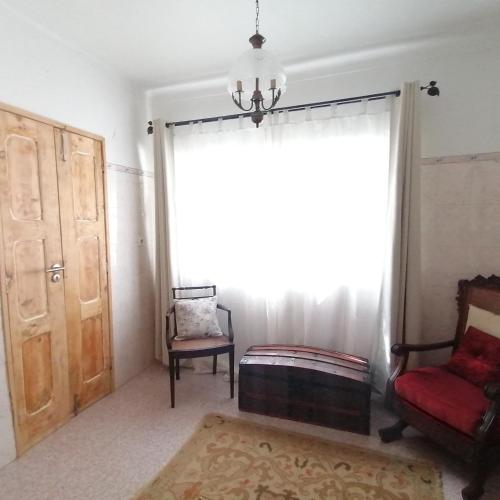 a living room with a window and a chair at Casa do Cabeço - Termas da Sulfúrea in Cabeço de Vide