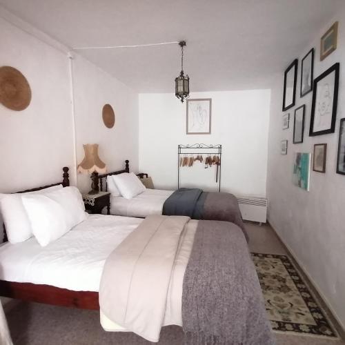 two beds in a bedroom with white walls at Casa do Cabeço - Termas da Sulfúrea in Cabeço de Vide
