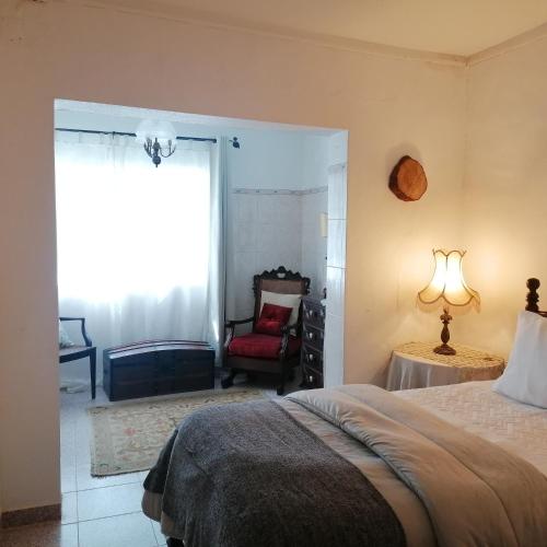 a bedroom with a bed and a chair and a window at Casa do Cabeço - Termas da Sulfúrea in Cabeço de Vide