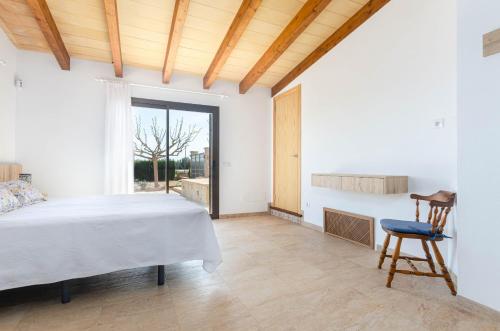 1 dormitorio con 1 cama, 1 silla y 1 ventana en YourHouse Cas Padri, lovely country house perfect for 2 guests, en Muro