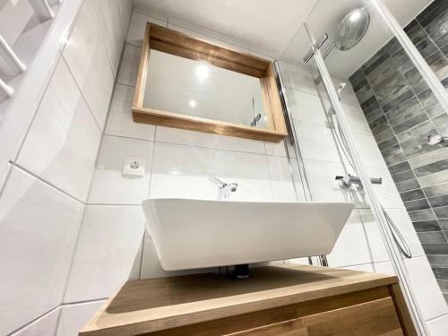 a bathroom with a white sink and a mirror at Gemütliches Appartement 10 Minuten zum Strand in Graal-Müritz