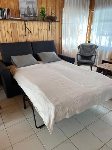 a large bed in a room with a chair at Majatalo Wanha-Pirtti in Iitti