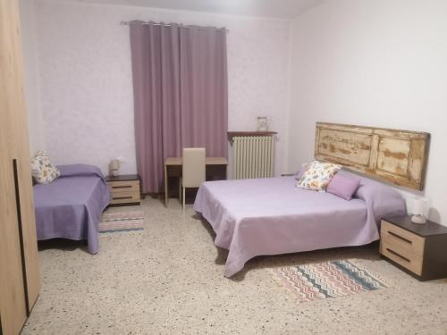 a hotel room with two beds and a table and a table at Agriturismo Poggio alla Luna in Gerfalco