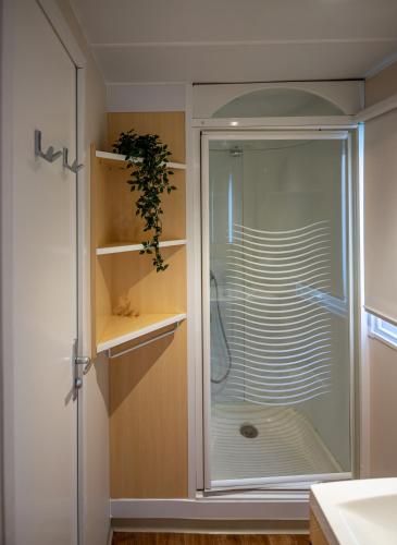 a shower with a glass door in a bathroom at Camping & Resort La Torre del Sol in Montroig