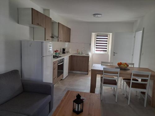 una cucina e una sala da pranzo con tavolo e divano di Apartment Jana a Korčula