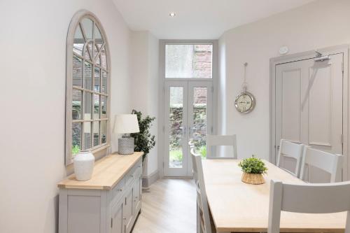 a dining room with white walls and a table and chairs at Stylish 3-Bedroom Edinburgh City Getaway in Edinburgh