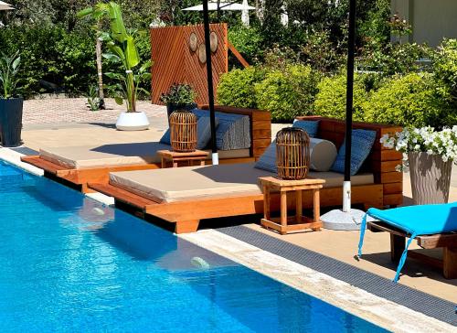 einen Pool mit 2 Liegestühlen und einem Pool in der Unterkunft Marbella Beach Hotel in Golem