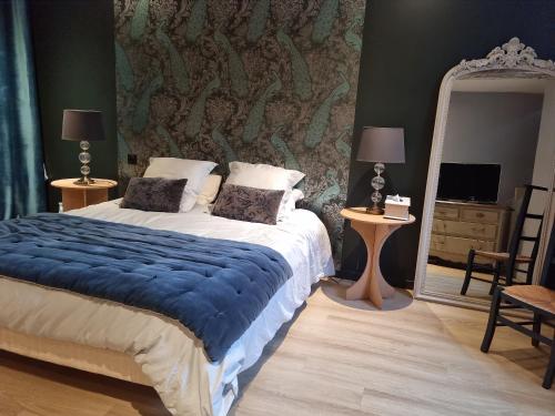 1 dormitorio con 1 cama grande y espejo en L'Aupinouse Chambre double Giroflée avec salle de bain privative, en La Suze-sur-Sarthe