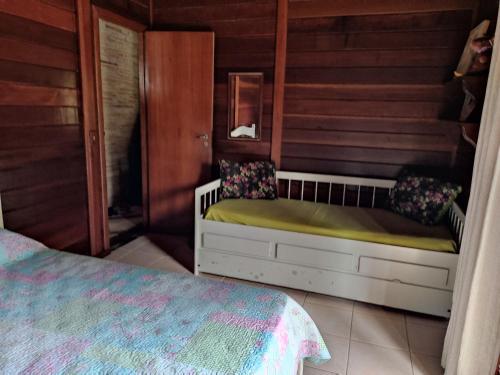 a bedroom with a bed in a room with wooden walls at Paz na Serra Teresopolis in Teresópolis