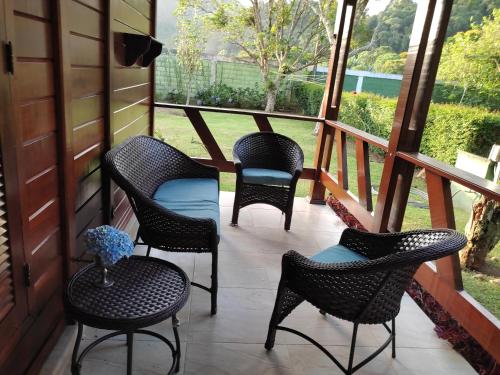 four chairs and a table on a porch at Paz na Serra Teresopolis in Teresópolis