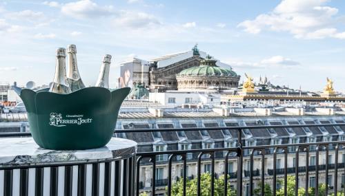 a bottle of champagne on a balcony with a view of the city at Kimpton - St Honoré Paris by IHG in Paris
