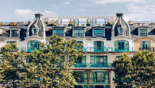 a tall building with trees in front of it at Kimpton - St Honoré Paris by IHG in Paris