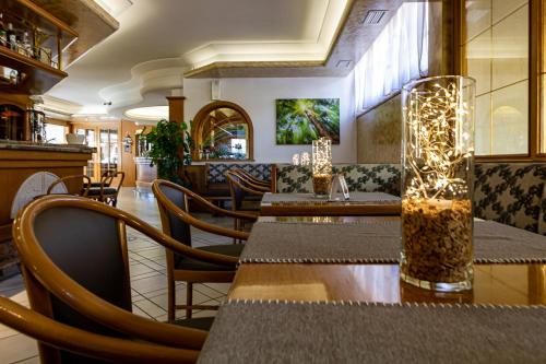 a restaurant with tables and chairs with lights on them at Hotel Arcobaleno in Fai della Paganella