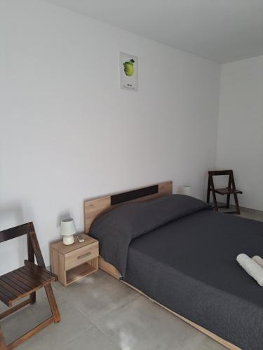 ein Schlafzimmer mit einem Bett, einem Stuhl und einem Tisch in der Unterkunft Apartment Jana in Korčula