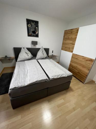 um quarto com uma cama e piso em madeira em Apartment 3 Gäste em Schörfling am Attersee