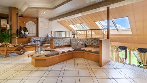 a living room with a couch and a staircase at Hotel Arcobaleno in Fai della Paganella