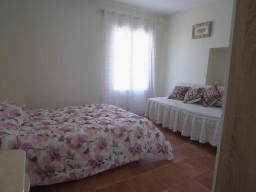 a bedroom with a bed and a bed and a window at Casa Rural Dehesa de Algar in Algar