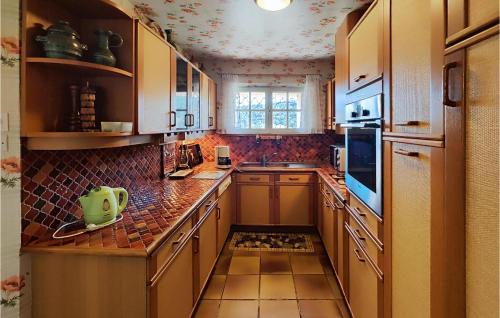 une cuisine avec des armoires en bois et un comptoir dans l'établissement 2 Bedroom Cozy Home In Cébazan, à Cébazan