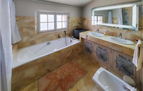 a large bathroom with two sinks and a tub and a tub at 2 Bedroom Cozy Home In Cbazan in Cébazan