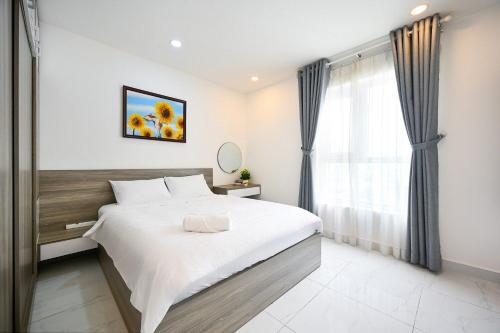 a bedroom with a large bed and a window at Bearshouse - Terra Royal in Ho Chi Minh City