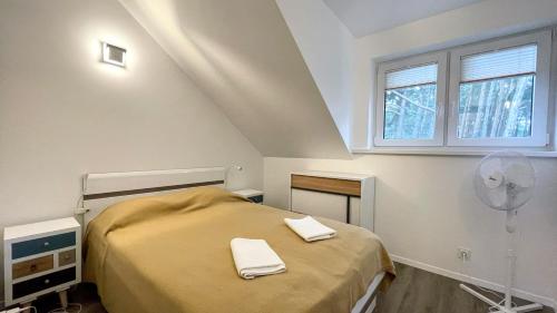 ein Schlafzimmer mit einem Bett mit zwei Handtüchern darauf in der Unterkunft Namelis Preiloje 3 in Preila