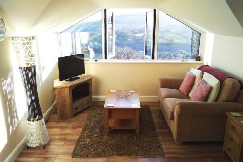 a living room with a couch and a tv at Birds Nest, Romantic getaway with stunning views in Matlock