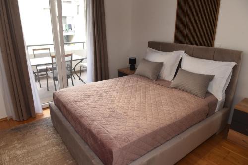 1 dormitorio con 1 cama y balcón con mesa en Navigo, en Ploče