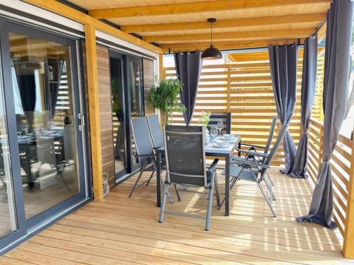 a patio with a table and chairs on a deck at La Mer Mobil Home in Biograd na Moru