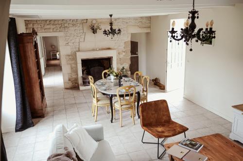 a dining room with a table and chairs and a fireplace at Château de La Vallade in Saint-Porchaire