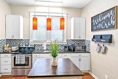 a kitchen with white cabinets and a wooden table at Charming and Historic Bungalow Near All in Tampa
