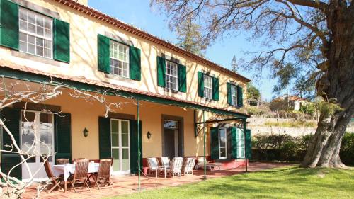 an exterior view of a house with green shutters at Quinta das Malvas - Quinta de Santa Luzia in Funchal