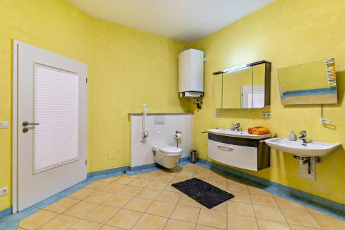 a yellow bathroom with a toilet and a sink at Ferienhaus Brigitte in Hornberg