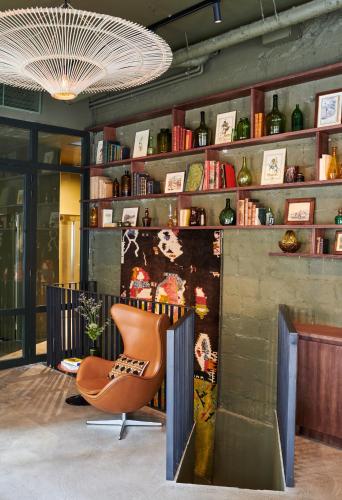 una habitación con una silla y una pared con estanterías en Hôtel Cartier, en Saint-Malo