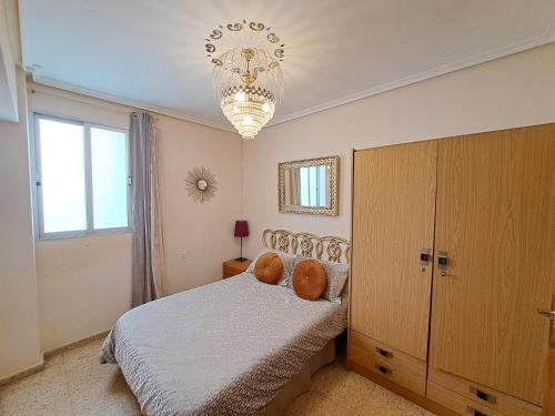 a bedroom with a bed and a chandelier at 3 bedroom flat with wifi in Valencia