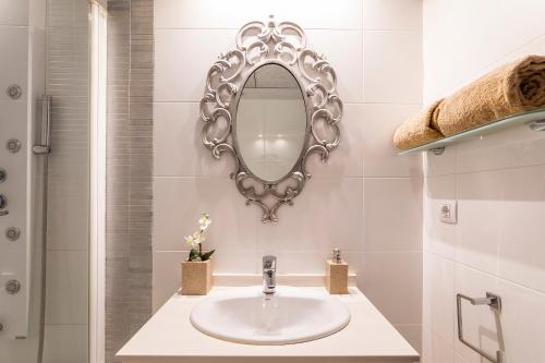 uma casa de banho com um lavatório e um espelho em Valencia Doble A Deluxe em Valência